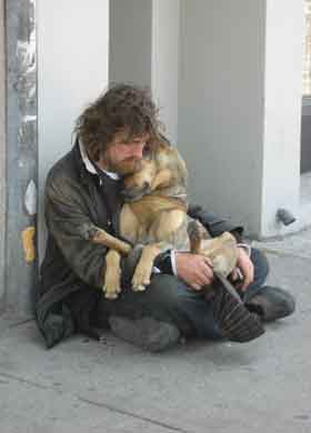 犬を抱くホームレスの写真