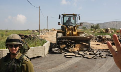 パレスチナの家屋を破壊するキャタピラー車のブルドーザー
