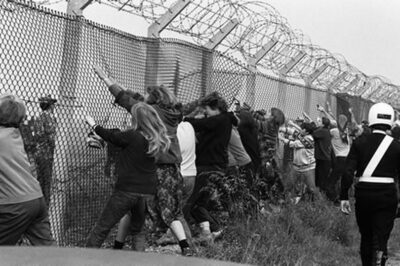 「基地のフェンスを引っ張る抗議パフォーマンスをするデモ隊」（ グリーナムコモン 1983年）